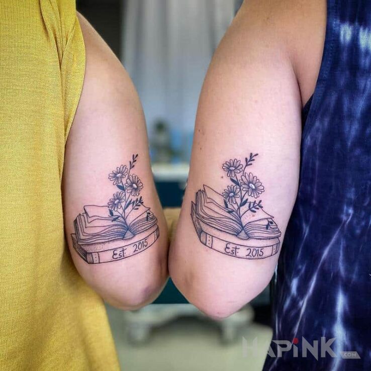 Tattoo Z miłości do czytania książek in black and gray motif and graphic / illustrative style on the upper arm