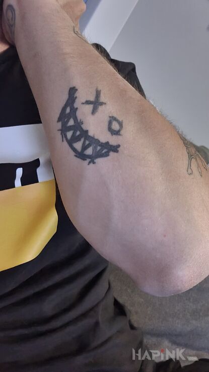 Tattoo Smile tattoo in black and gray motif and graphic / illustrative style On the arm