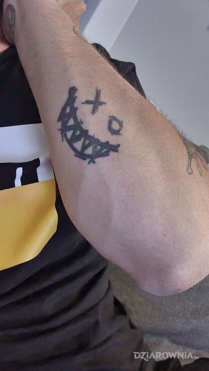 Tatuaż smile tattoo w motywie czarno-szare na przedramieniu