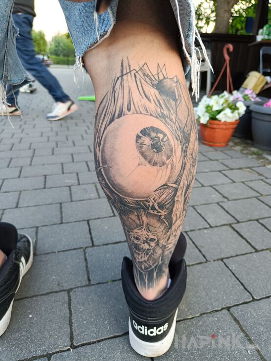Tattoo Oko in black and gray motif and realistic style on the calf