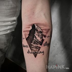 Tattoo Mountains on the forearm motif: lettering style: realistic