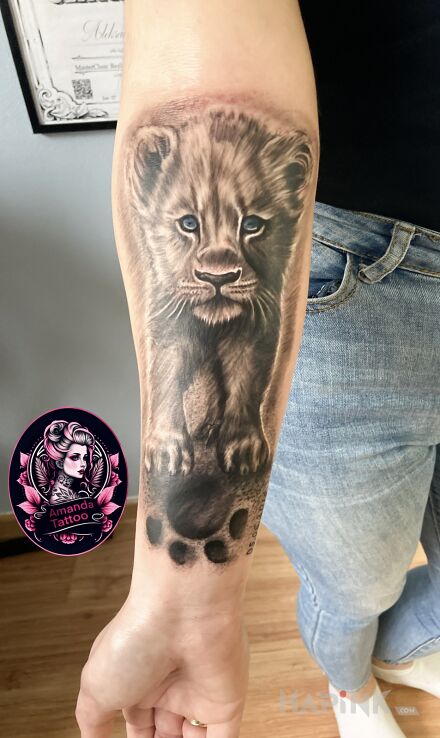 Tattoo Simba in black and gray motif and realistic style on the forearm