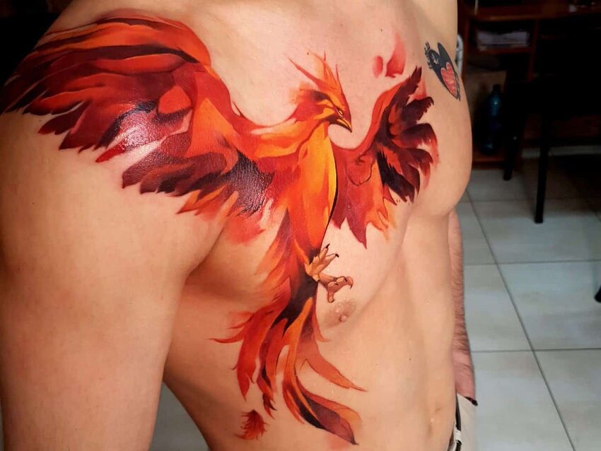 czerwono-pomarańczowy tatuaż feniksa na braku i klatce piersiowej
