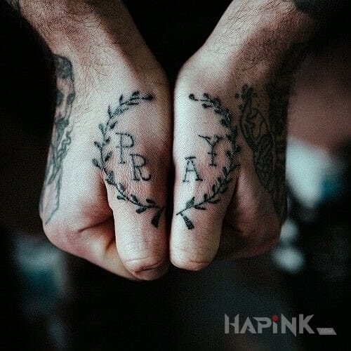 Tattoo PRAY in lettering motif on the fingers