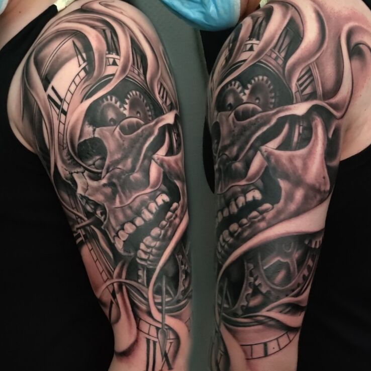 Tatuaż czaszka w zegarze w motywie czarno-szare i stylu abstrakcyjne na ramieniu