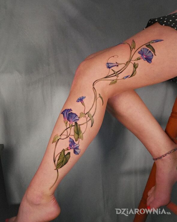 Tatuaż pięknie wykomponowany w motywie florystyczne i stylu realistyczne na łydce