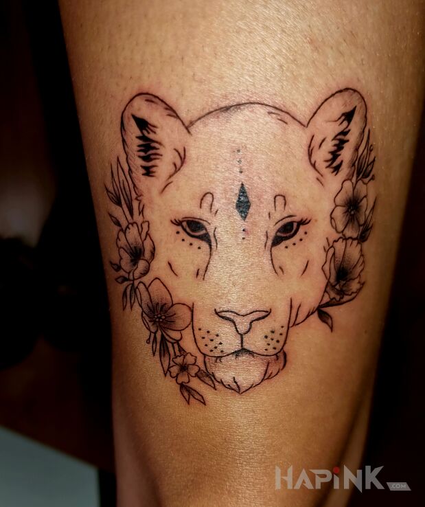 Tattoo Wymarzona lwica in flowers motif and graphic / illustrative style on the leg