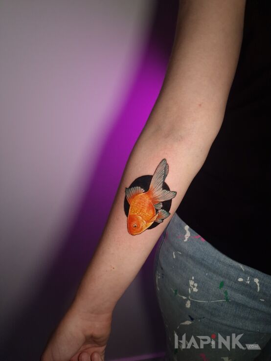 Tattoo Złota rybka in colorful motif and realistic style on the forearm