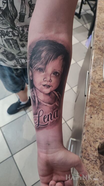 Tattoo Portrecik in black and gray motif and realistic style on the forearm