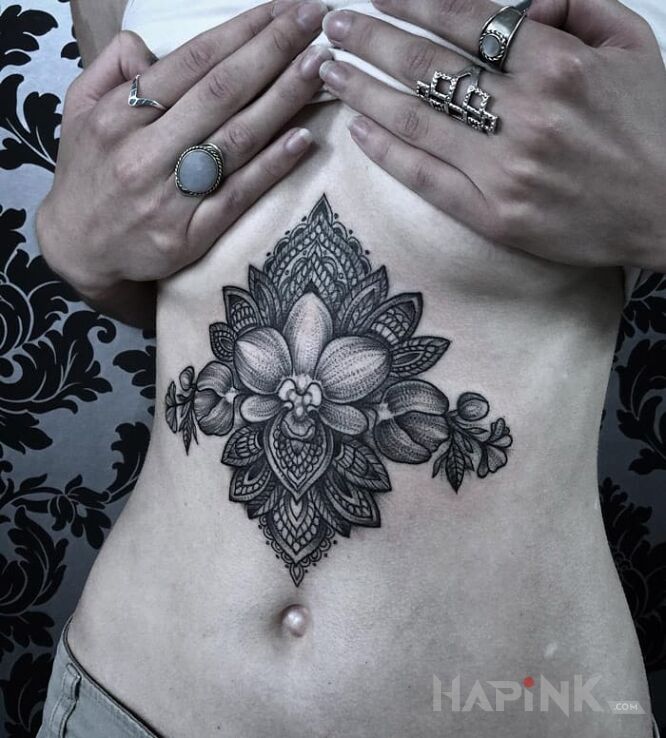 Tattoo Orchidea in black and gray motif and graphic / illustrative style on the stomach