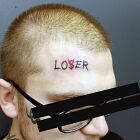 Tatuaż  na czole napis lover loser na twarzy, motyw: napisy, styl: ignorant