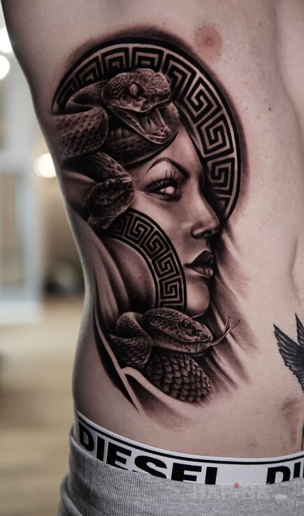 Tattoo Medusa in black and gray motif and realistic style on the ribs
