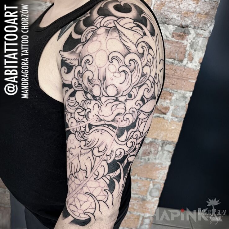 Tattoo Komainu in black and gray motif and japanese / irezumi style on the upper arm