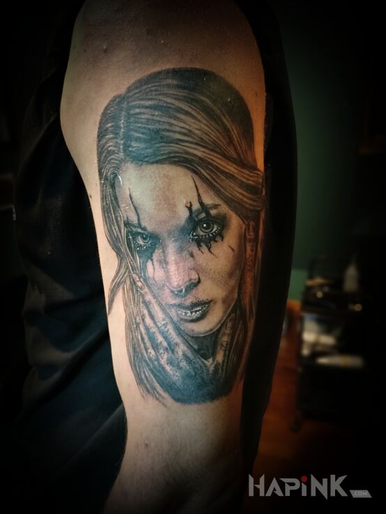 Tattoo Lady on dark in black and gray motif and realistic style on the upper arm
