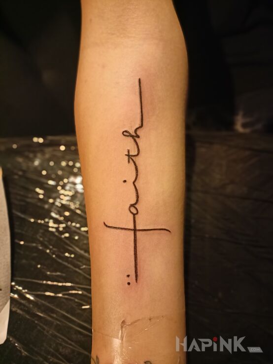 Tattoo Faith in lettering motif and calligraphy style On the arm