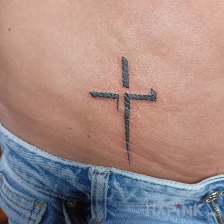 Tattoo Krzyż in religious motif and minimalistic style on the stomach
