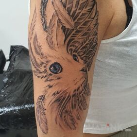 Tattoo Cat on the upper arm motif: wings style: realistic