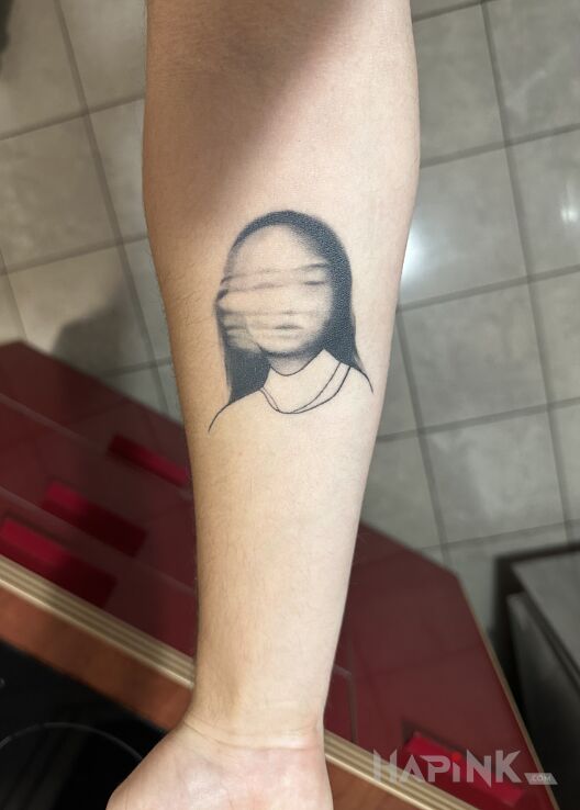 Tattoo Rozmyta twarz in dark motif and graphic / illustrative style on the forearm
