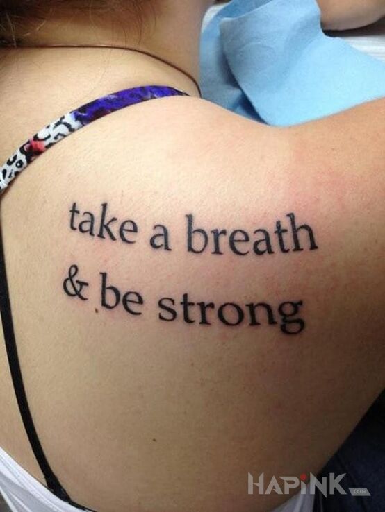 Tattoo Bądź silny in lettering motif on the shoulder blades