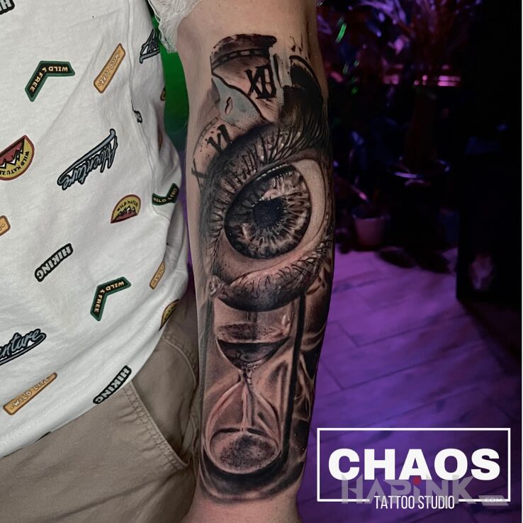 Tattoo KLASYCZEK OKO KLEPSYDRA in dark motif and realistic style On the arm