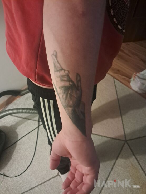 Tattoo Patrz komu ufasz in black and gray motif and realistic style On the arm