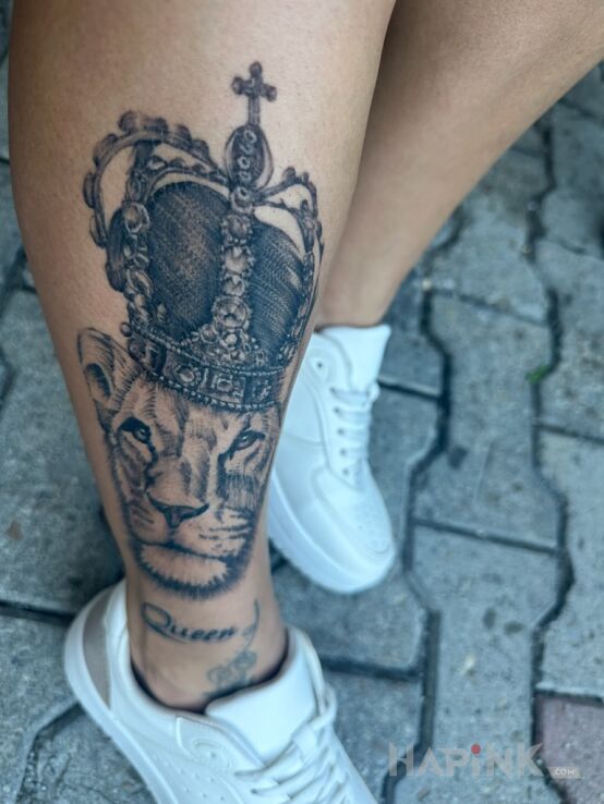 Tattoo Lion in black and gray motif and realistic style on the leg