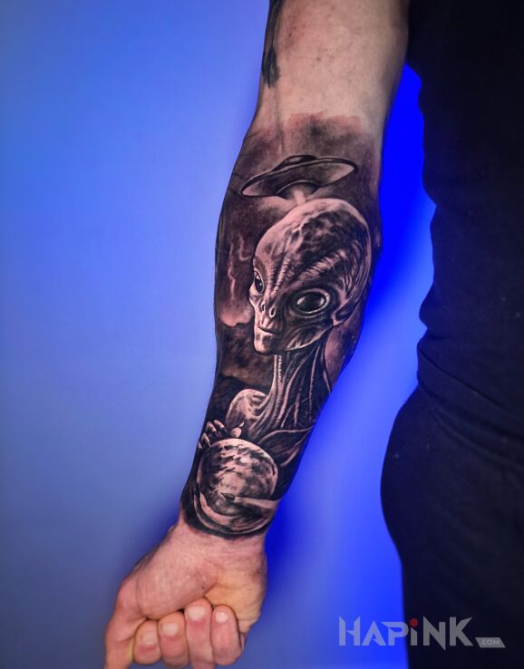 Tattoo Ufo in science fiction motif and realistic style on the forearm