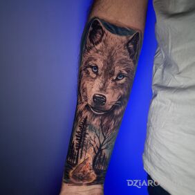 Tatuaż Wilk a pod nim ognisko w lesie na przedramieniu motyw: zwierzęta styl: realistyczne