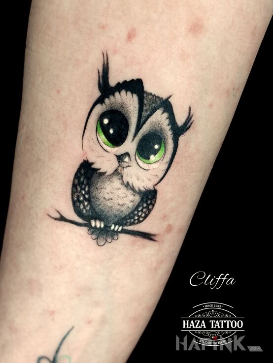 Tattoo Owl with cute eyes in black and gray motif and graphic / illustrative style on the forearm