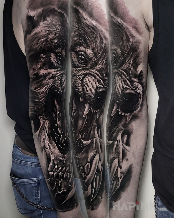 Tattoo Wilczek in black and gray motif and realistic style on the upper arm