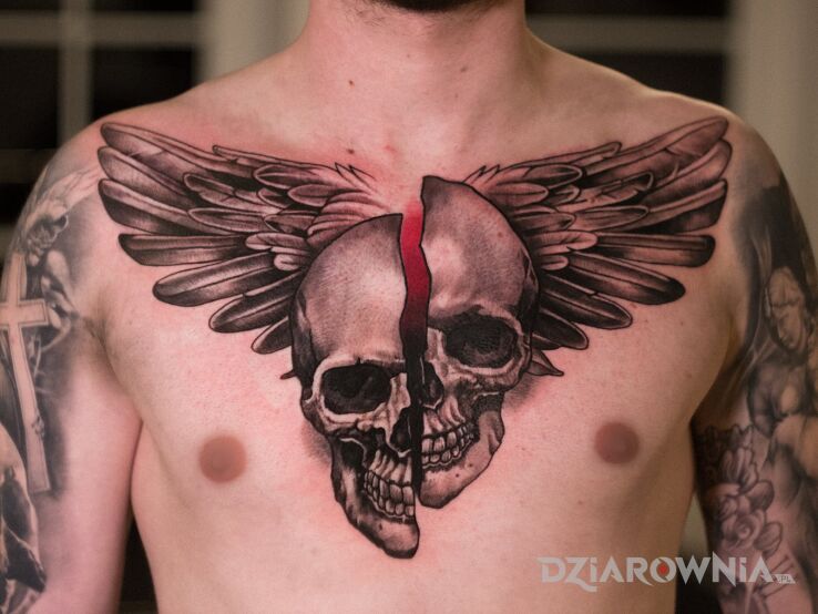 Tatuaż  czaszki ze skrzydłami na klatce piersiowej w motywie czaszki i stylu blackwork / blackout między piersiami