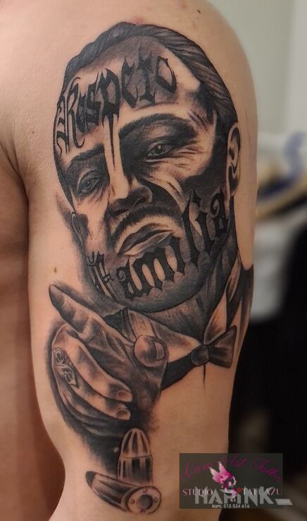 Tattoo Ojciec Chrzestny in black and gray motif and realistic style on the upper arm