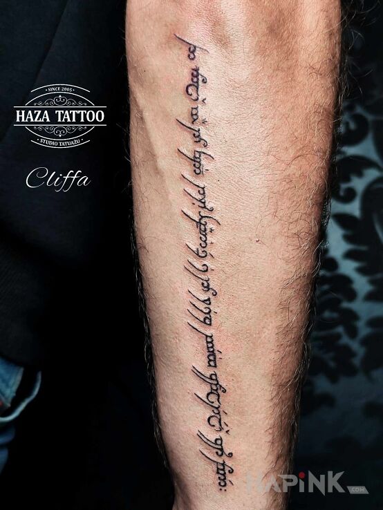 Tattoo Tattoo inscription in fantasy motif and calligraphy style on the forearm