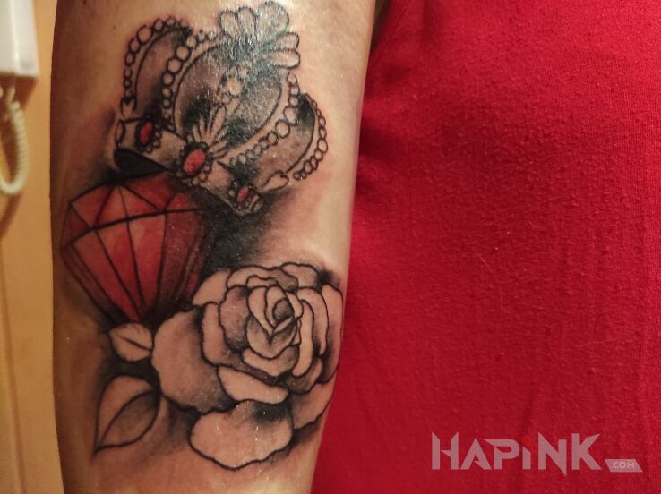 Tattoo Korona z diamentem in flowers motif and realistic style on the upper arm
