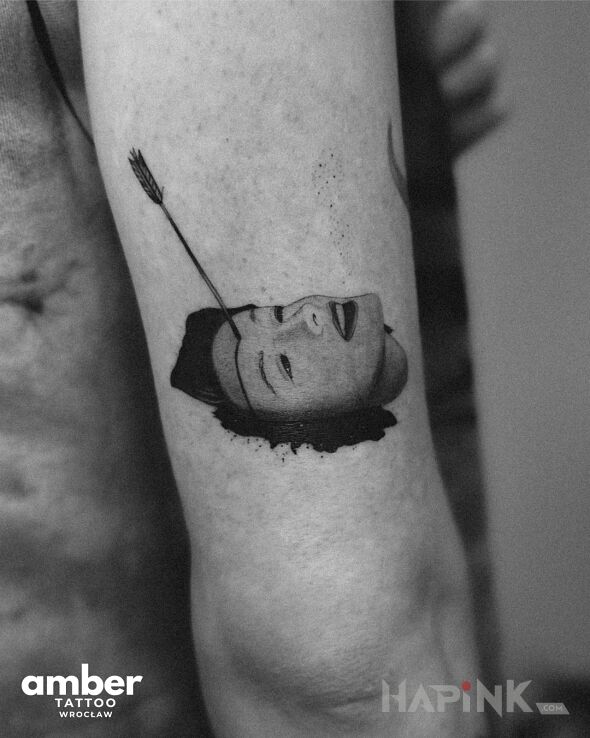 Tattoo Headshoot in faces motif and surrealistic style on the upper arm