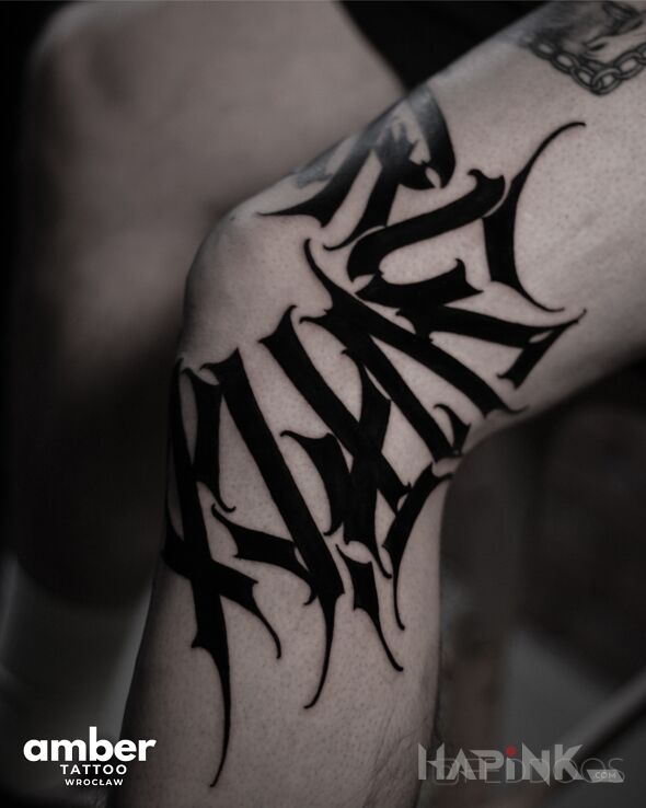 Tattoo Czarna kaligrafa dookoła kolana in lettering motif and calligraphy style on the knee