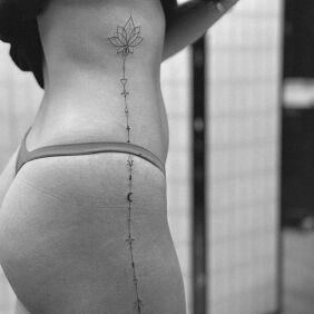 Tatuaż Jak po sznurku - kwiat lotosu na żebrach motyw: ornamenty styl: kontury / linework