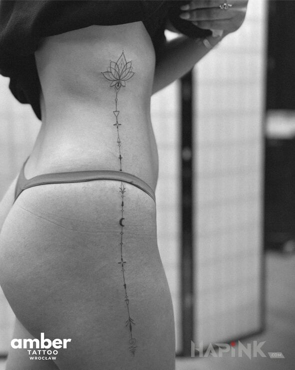 Tattoo Jak po sznurku - kwiat lotosu in ornaments motif and minimalistic style on the ribs