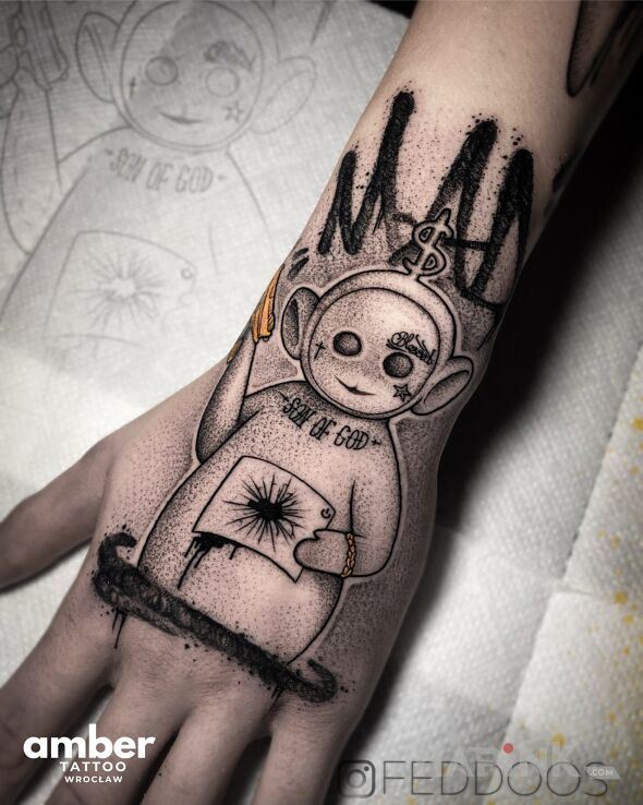 Tattoo STUDIO TATUAŻU AMBER TATTOO in black and gray motif and graphic / illustrative style on the hand