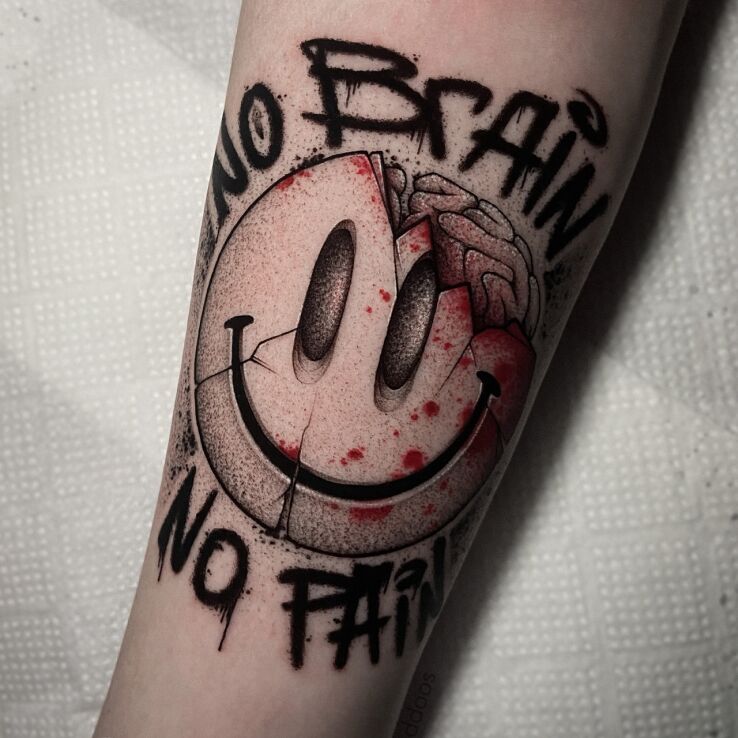 Tattoo Smiling emoji in black and gray motif and graphic / illustrative style on the forearm