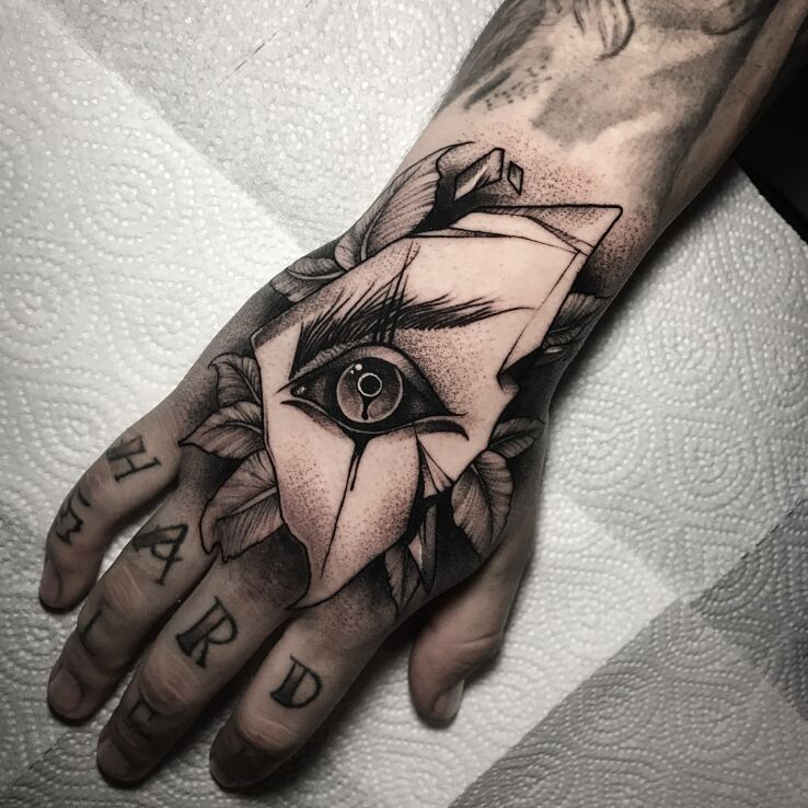 Tattoo Eye with rose leaves in floral motif and graphic / illustrative style on the hand
