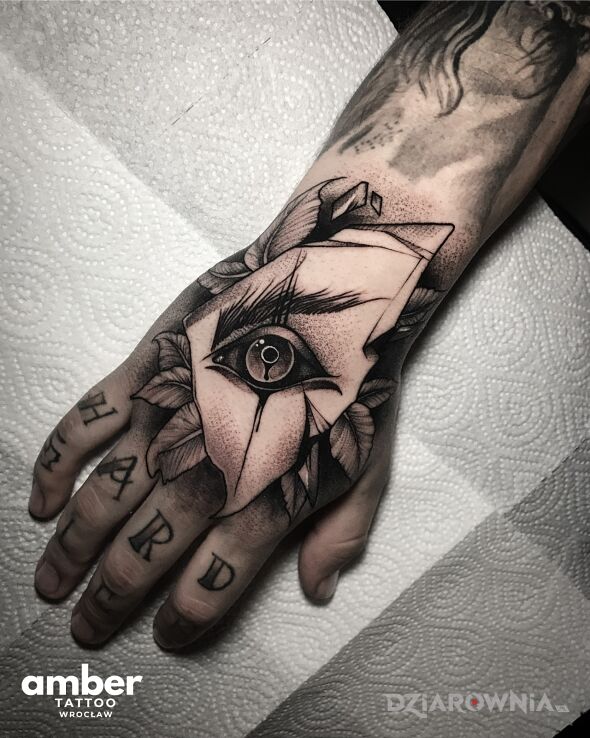 Tatuaż oko z liśćmi róży w motywie czarno-szare i stylu dotwork na ręce