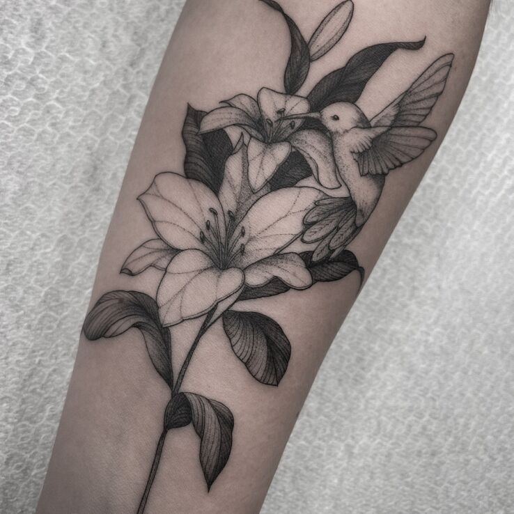 Tattoo Delicate flower with a hummingbird in flowers motif and graphic / illustrative style on the forearm