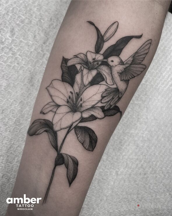 Tatuaż delikatny kwiatek z kolibrem w motywie florystyczne i stylu dotwork na przedramieniu