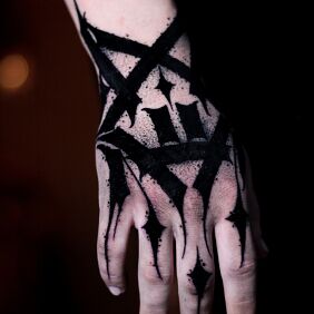 Tatuaż Dłoń maźnięta na czarno na ręce motyw: criminal lettering styl: blackwork / blackout