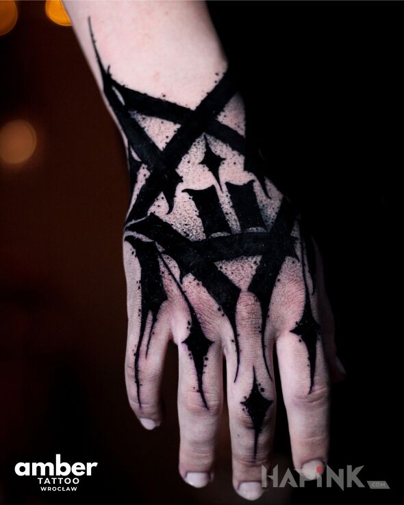Tattoo Dłoń maźnięta na czarno in criminal lettering motif and blackwork / blackout style On the arm