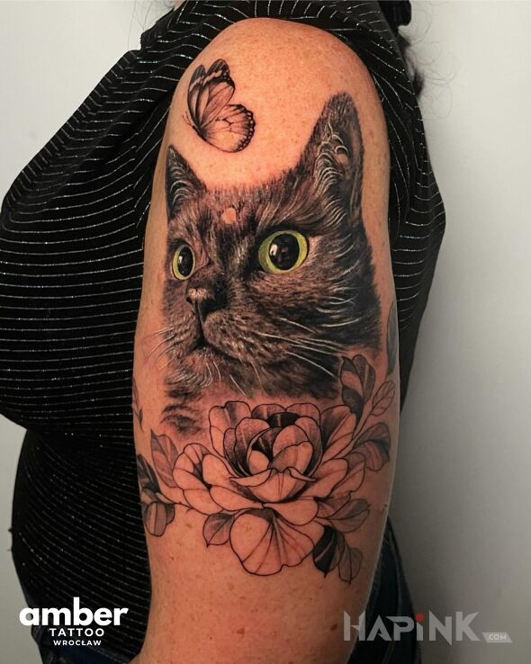 Tattoo Kot w kwiatach in butterflies motif and realistic style On the arm
