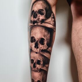 Tattoo Pile of skulls on the calf motif: black and gray style: realistic