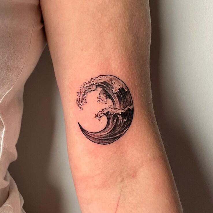 Tattoo Minimalist Waves in black and gray motif and minimalistic style on the bicep