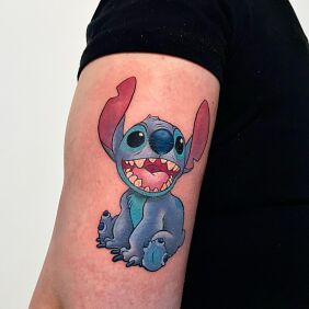 Tatuaż Stitch na ramieniu motyw: postacie styl: kreskówkowe / komiksowe